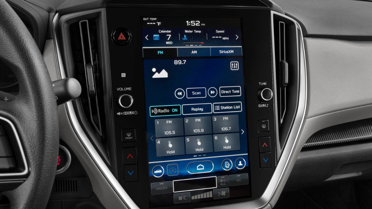 Subaru Crosstrek 2025 vu de l’intérieur avec l’écran tactile central affichant les commandes radio FM, dans un environnement moderne et technologique.