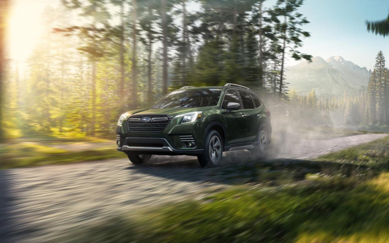 vue latérale avant d'une Subaru Forester 2024 sur une route en forêt
