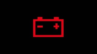 Icône rouge du témoin de circuit de charge en forme de batterie avec symboles plus et moins sur fond noir.