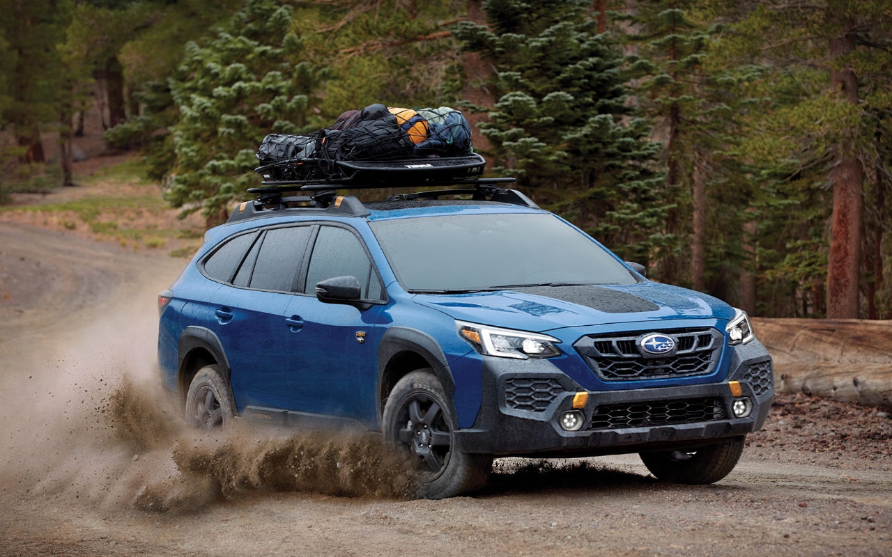 vue latérale avant d'un Subaru Outback Wilderness 2025 sur une route de campagne