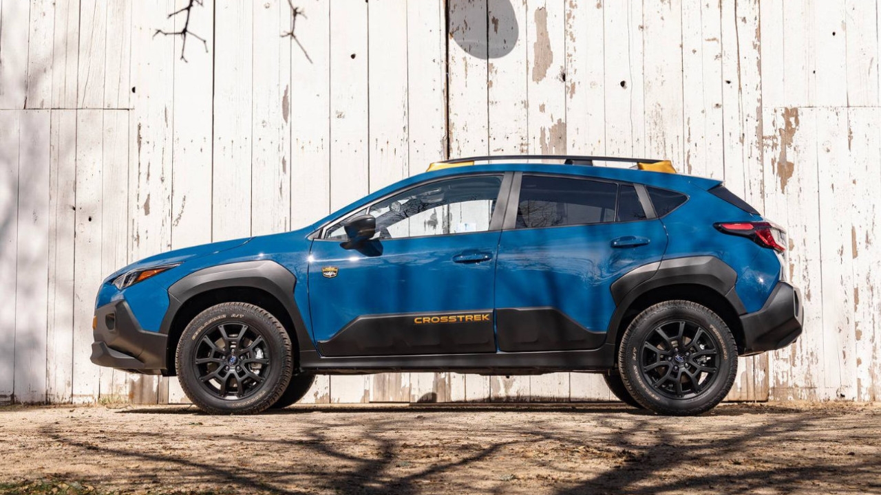 vue latérale d'une Subaru Crosstrek 2025 devant une clôture de bois blanche usée