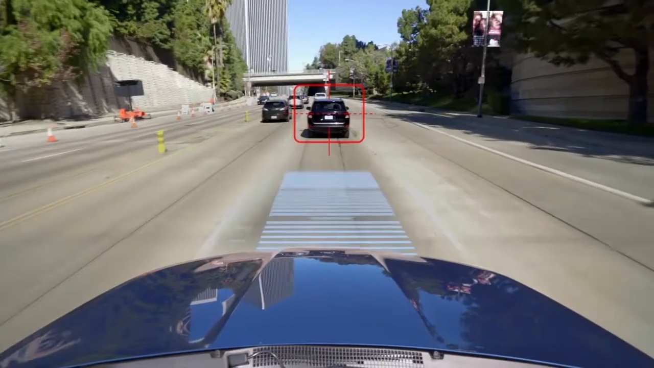 Vue du capot d’un Subaru bleu en circulation urbaine avec affichage virtuel ciblant un véhicule noir devant, illustrant le fonctionnement du régulateur de vitesse adaptatif EyeSight.