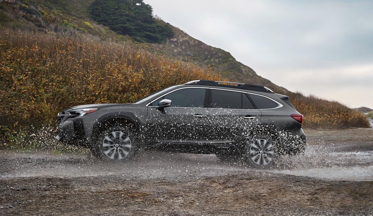 vue latérale d'une Subaru Outback 2024 sur un sentier boueux