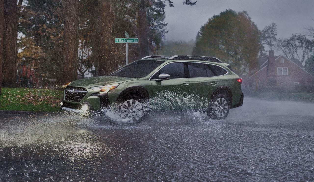 Le Subaru Outback 2024 avec ses phares allumés, roulant dans une rue inondée.
