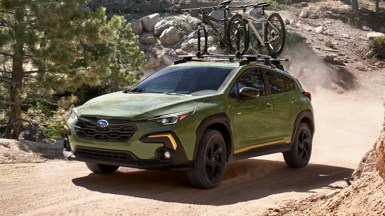 vue latérale avant d'un Subaru Crosstrek 2025 transportant des vélos sur un sentier de montagne