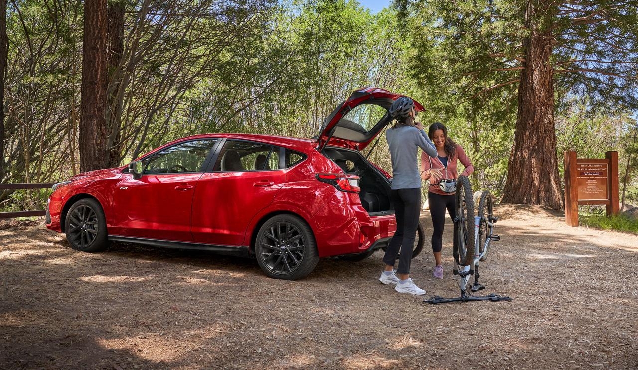 Deux personnes ouvrant le coffre du Subaru Impreza 2024.