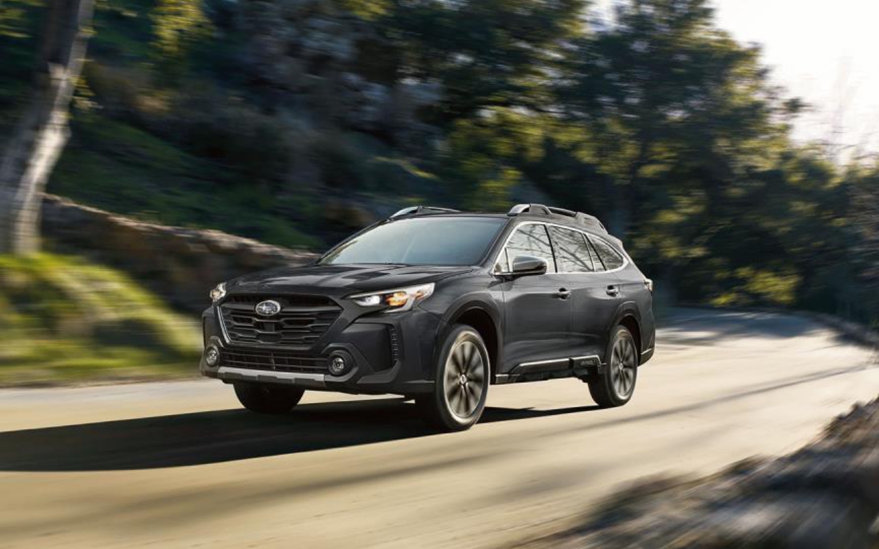 vue latérale avant d'une Subaru Outback 2024 sur une route de campagne