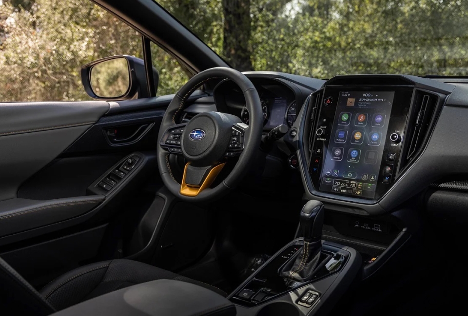Habitacle du Subaru Crosstrek Wilderness 2025 avec écran tactile central de 11,6 pouces et garnitures cuivrées sur le volant.