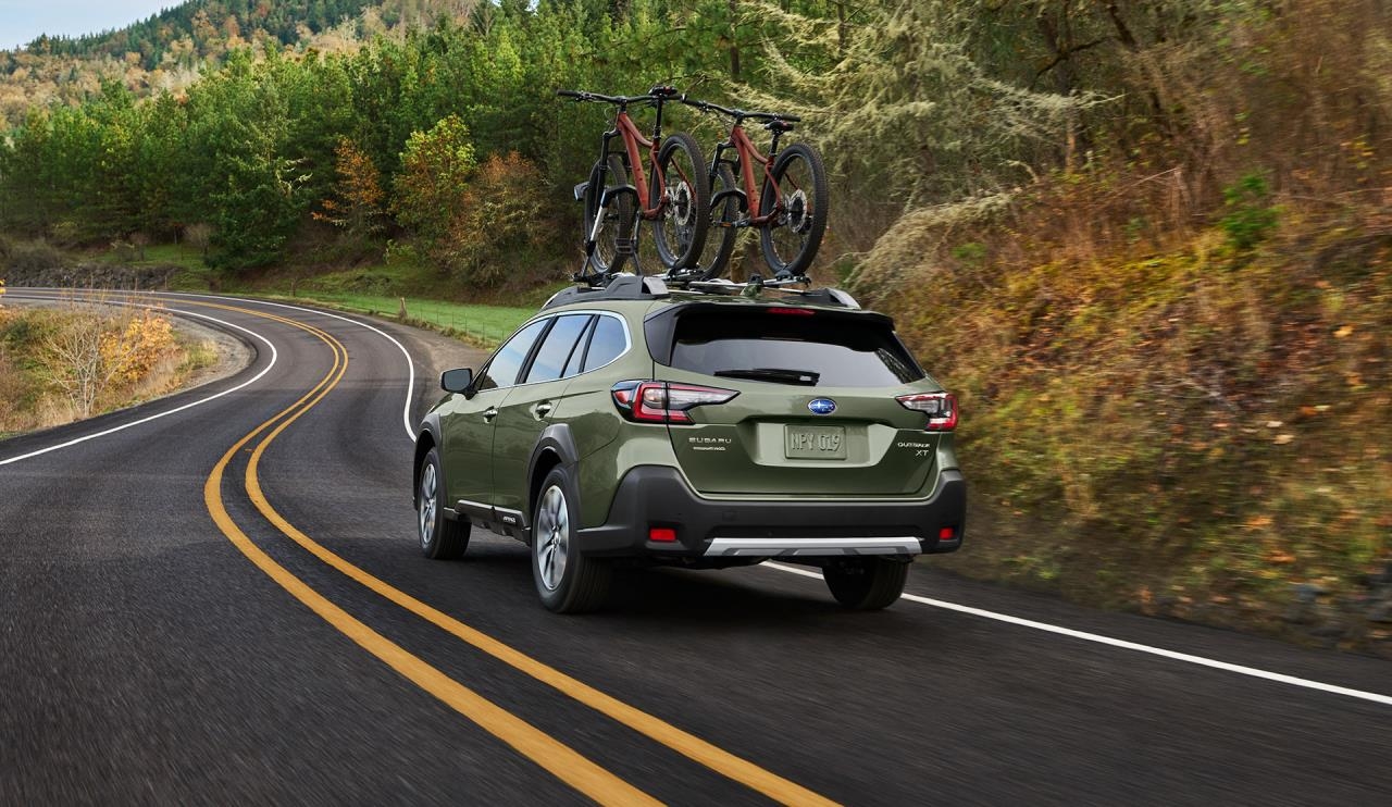 vue latérale arrière d'une Subaru Outback 2024 sur une route de campagne