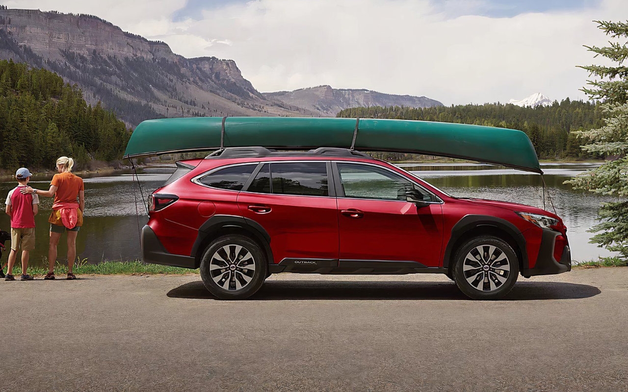 vue latérale d'un Subaru Outback 2025 avec un canot sur fixé sur son toit, près d'un lac